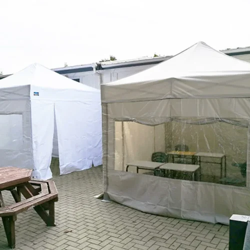 two pop up gazebos with sides in white and grey